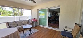Sarasota house for rent - A balcony with a table and chairs overlooking a pool.
