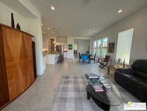 Rancho Mirage house for rent - A living room with a black couch, a coffee table, and a wooden cabinet.