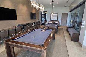 Rancho Mirage house for rent - A pool table is in the middle of a room with a TV and a bench.