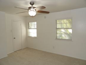 Dallas apartment for rent - A room with a ceiling fan and two windows.