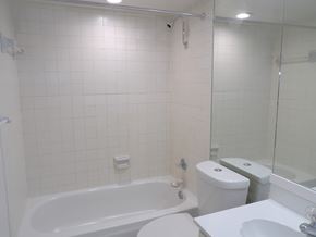 Dallas apartment for rent - A white bathroom with a tub, toilet, and sink.