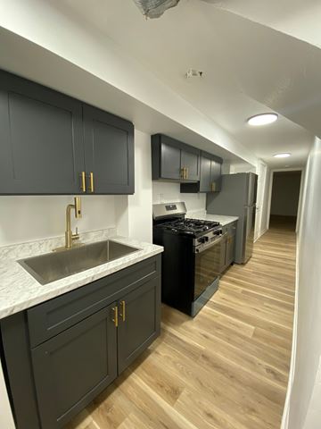 Louisville apartment for rent - A kitchen with dark wood cabinets and a white marble countertop.