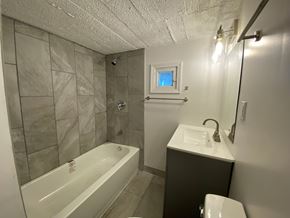 Louisville apartment for rent - A bathroom with a white tub, sink, and toilet.