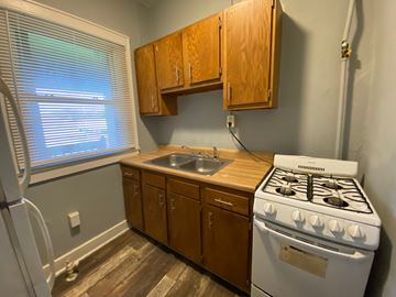 Louisville apartment for rent - A kitchen with a white stove and wooden cabinets.