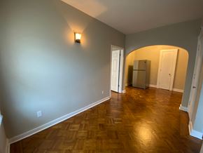 Louisville apartment for rent - A room with wooden flooring and a refrigerator in the corner.