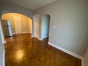 Louisville apartment for rent - A room with wooden floors and arched doorways.