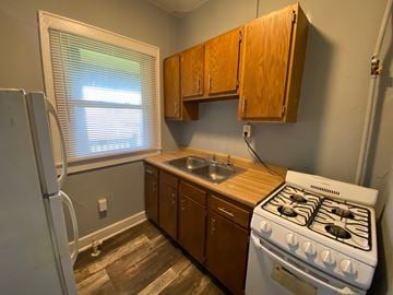 Louisville apartment for rent - A kitchen with a white stove and wooden cabinets.