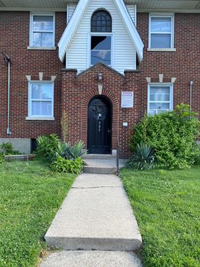 Louisville apartment for rent - A brick house with a black door and a sign on the front.