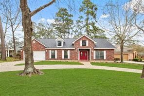 Conroe house for rent - A red brick house with a grey roof and a red door.