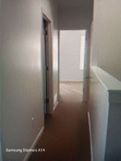 Baltimore house for rent - A long hallway with white walls and a brown floor.