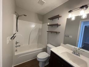 Portland house for rent - A white bathroom with a toilet, sink, and bathtub.