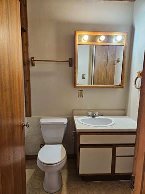 Swift Current apartment for rent - A bathroom with a toilet, sink and mirror.