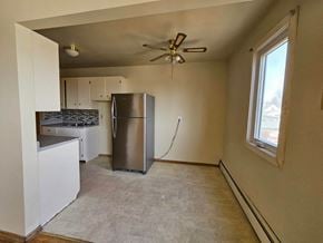 Swift Current apartment for rent - A kitchen with a refrigerator, stove, and cabinets.