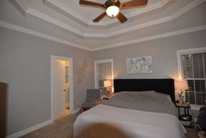 Hendersonville house for rent - A bedroom with a bed, a ceiling fan, and a painting on the wall.