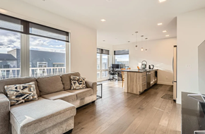 Denver house for rent - A modern living room with a large window and a kitchen area.