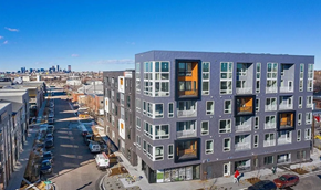 Denver house for rent - A modern apartment building with a parking lot in front.