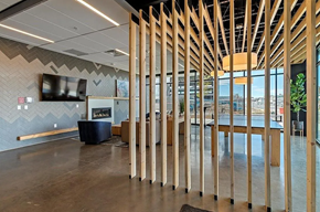 Denver house for rent - A modern office space with a wood slat partition and a fireplace.