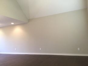 Portland house for rent - A room with a wooden floor and two lights on the wall.