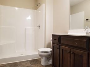 Portland house for rent - A white toilet sits in a bathroom next to a white sink.