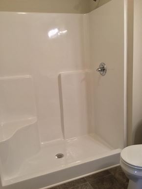 Portland house for rent - A white toilet sits next to a white bathtub in a bathroom.