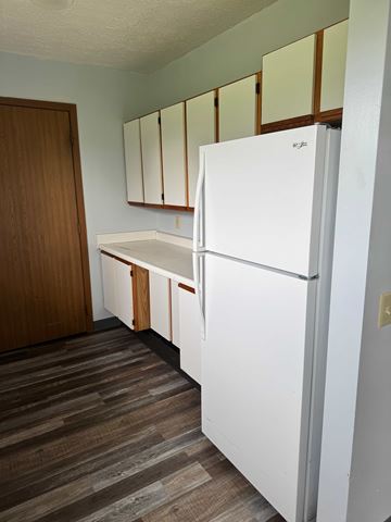 New  Waterford apartment for rent - A white refrigerator in a kitchen with wooden cabinets.
