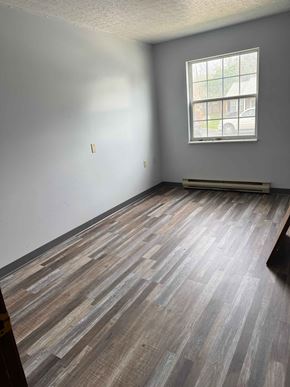 New  Waterford apartment for rent - A room with a window and wooden flooring.