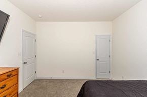 Jacksonville house for rent - A bedroom with a bed, dresser, and two doors.