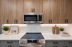 Charleston apartment for rent - A modern kitchen with a stainless steel oven and microwave above a black induction cooktop.