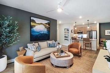 Charleston apartment for rent - A living room with a large painting on the wall and a ceiling fan.