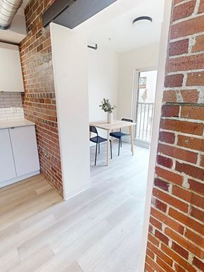 Halifax apartment for rent - A room with a brick wall and a white cabinet.