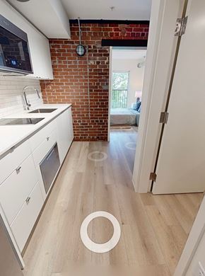 Halifax apartment for rent - A kitchen with white cabinets and a brick wall.