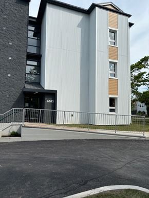 Halifax apartment for rent - A tall building with a grey and brown facade and a black awning.