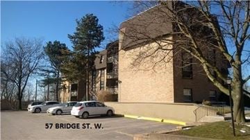 Belleville apartment for rent - A building with the address 57 Bridge St. W. is shown with cars parked in front.