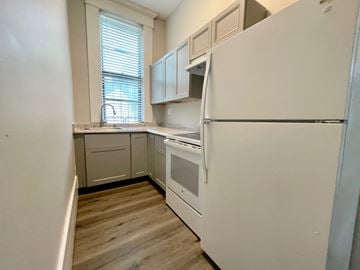 Louisville apartment for rent - A kitchen with white appliances and wooden floors.