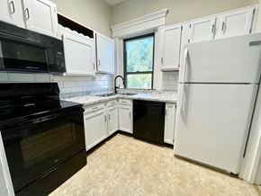 Louisville apartment for rent - A kitchen with black appliances and white cabinets.