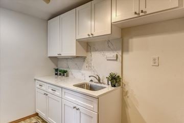 Spokane house for rent - A kitchen with white cabinets and a marble backsplash.