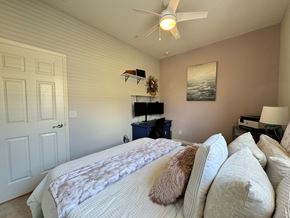 Bradenton house for rent - A bedroom with a large bed and a ceiling fan.