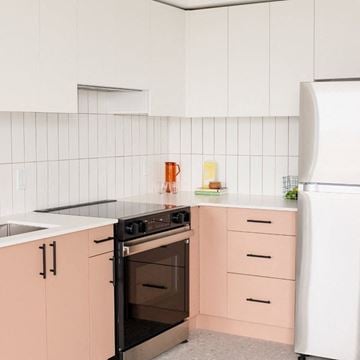 Victoria apartment for rent - A kitchen with pink cabinets and a white fridge.