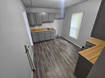 Lima house for rent - A kitchen with wood flooring and a window with blinds.