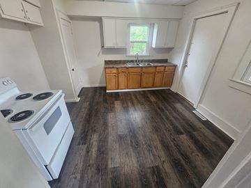 Lima house for rent - A kitchen with a white stove and wooden cabinets.