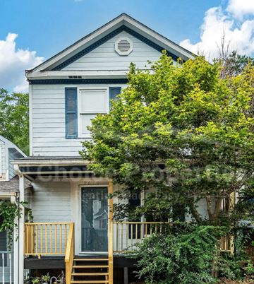 Birmingham house for rent - A house with a white exterior and a yellow staircase leading to a balcony.