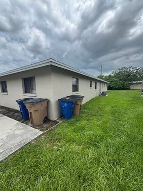 Fort Myers apartment for rent - A house with two trash bins in front of it.