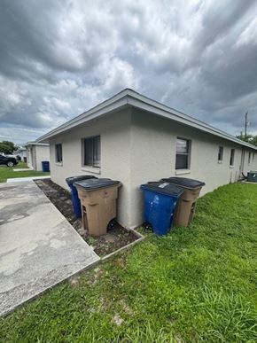 Fort Myers apartment for rent - A house with two trash bins in front of it.