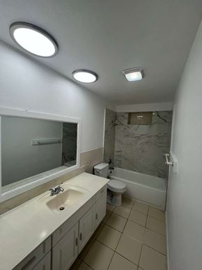 Fort Myers apartment for rent - A bathroom with a sink, toilet, and mirror.