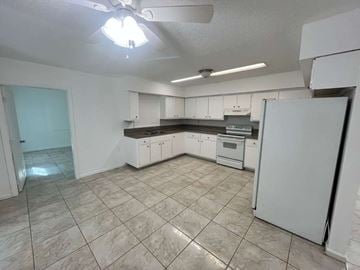 Fort Myers apartment for rent - A kitchen with white cabinets and a white refrigerator.