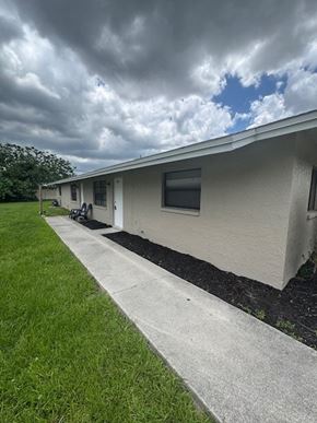 Fort Myers apartment for rent - A white house with a grey roof and a white fence.