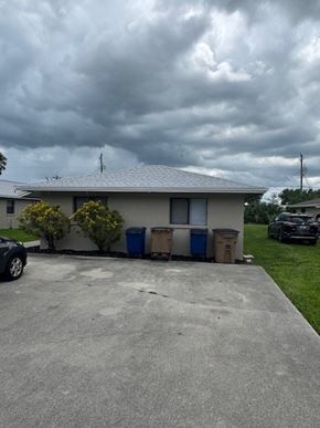 Fort Myers apartment for rent - A house with a grey roof and a dark sky above.