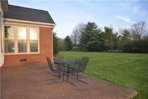 Brentwood house for rent - A patio with a table and chairs is in front of a house.