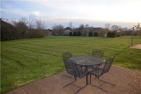 Brentwood house for rent - A table and chairs set on a patio with a lawn and houses in the background.