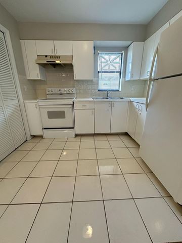 Fort Myers apartment for rent - A kitchen with white appliances and cabinets.